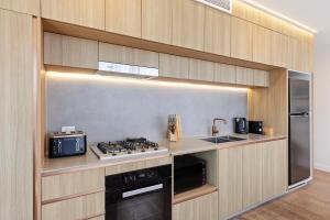 a kitchen with a stove and a sink at Lux Style Spacious 1 Bed Apt, Pool , Parking in Brisbane +4 photos