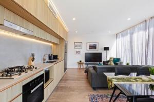 a kitchen and living room with a stove and a couch at Lux Style Spacious 1 Bed Apt, Pool , Parking in Brisbane