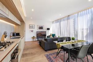 a kitchen and living room with a couch and a table at Lux Style Spacious 1 Bed Apt, Pool , Parking in Brisbane