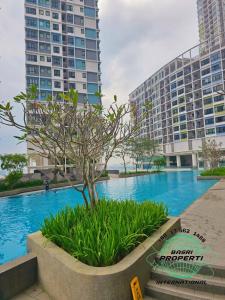 a swimming pool in front of two tall buildings at I-City Hyde 2RooM 2TandaS BASRi PROPERTi in Shah Alam