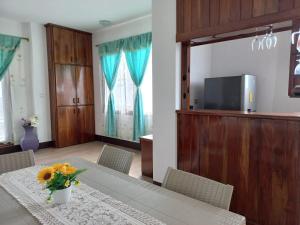 a dining room with a table with flowers on it at Vami's House in Puerto Villamil