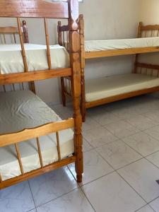 a set of three wooden bunk beds in a room at RoseMarAzul Temporadas in Cabo Frio