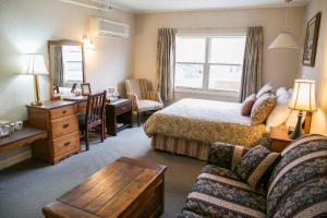 ein Hotelzimmer mit einem Bett und einem Schreibtisch in der Unterkunft Lanes Privateer Inn in Liverpool