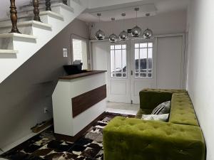 a living room with a green couch and a staircase at Terraza hostel in Itajaí