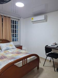a bedroom with a bed and a desk with a computer at Habitación Independiente El paraíso - Cerca al Gran Malecón del Rio-Barranquilla in Barranquilla