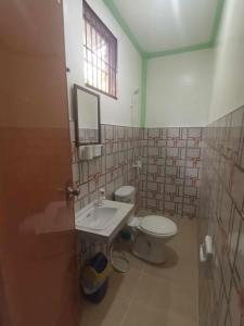 un bagno con un water, un lavandino e una finestra di Katulganan Inn a Panglao