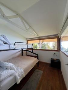 a bedroom with two bunk beds and a window at Cabaña Guarumo de la Sierra - Minca in El Campano