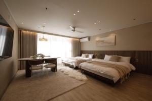 a bedroom with two beds and a table and a dining room at Hongdae St10, wide,bright & stylish house in Seoul