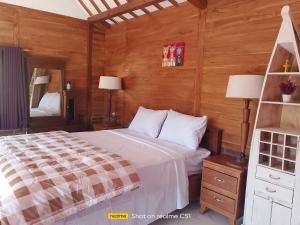 a bedroom with a bed and two lamps and a mirror at Wiwik sweet villa in Amed
