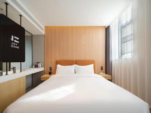 Ein Bett oder Betten in einem Zimmer der Unterkunft 桔作酒店（郑州经开中原福塔东地铁站店）