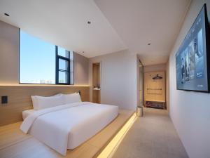 Ein Bett oder Betten in einem Zimmer der Unterkunft 桔作酒店（郑州经开中原福塔东地铁站店）