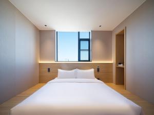 Ein Bett oder Betten in einem Zimmer der Unterkunft 桔作酒店（郑州经开中原福塔东地铁站店）