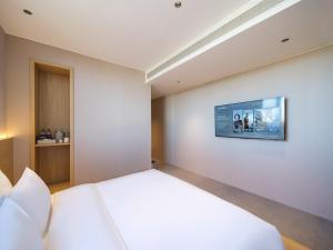 Ein Bett oder Betten in einem Zimmer der Unterkunft 桔作酒店（郑州经开中原福塔东地铁站店）
