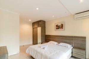 a bedroom with a large bed with white sheets at Family Only Villa Mountain View - De Reiz Kesuma Syariah 3BR in Bandung