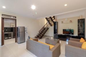 a living room with couches and a kitchen and a staircase at Family Only Villa Mountain View - De Reiz Kesuma Syariah 3BR in Bandung +10 photos