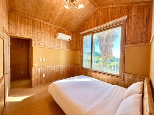Postel nebo postele na pokoji v ubytování Jeju Smile Pension
