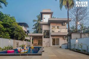 una casa con piscina delante en StayVista at Serenity Shores with Pool, Bonfire, Lawn, en Alibaug
