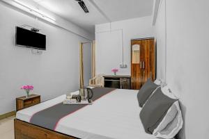 a bedroom with a bed with a tv on the wall at Hotel O Homely Stay in Aurangabad