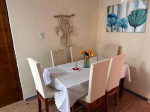 a table with chairs and a vase of flowers on it at Casa Isis in Constitución