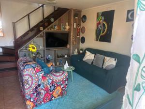 a living room with a blue couch and a tv at Casa Isis in Constitución
