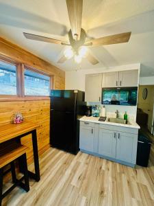 a kitchen with a ceiling fan and a black refrigerator at Lake Life 30 mm on the lake in Sunrise Beach