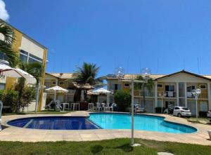 ein Schwimmbad vor einem Gebäude in der Unterkunft Apart Mont hebrom Rede tonziro in Porto Seguro