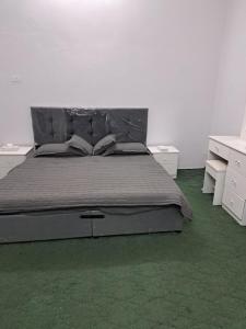 a bedroom with a large bed with green carpet at شقة مفروشة in Al Baha
