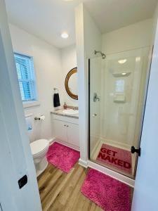 a bathroom with a shower and a toilet with pink mats at Terrific lake view On the shoreline in Sunrise Beach
