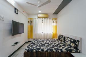 a bedroom with a bed and a flat screen tv at ZenStays - Premium Service Apartment in Mulund West in Mumbai