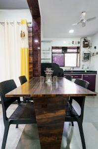 a dining room with a wooden table and chairs at ZenStays - Premium Service Apartment in Mulund West in Mumbai