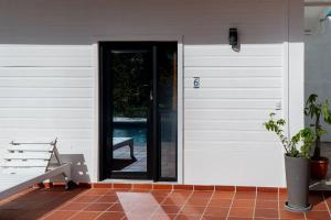 a door to a house with a bench next to it at Estancia Florencia Hab 6 in Tela