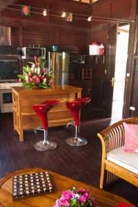 a kitchen with red chairs and a table with a counter at Robinson's Cove Villas - Deluxe Wallis Villa in Papetoai +38 photos