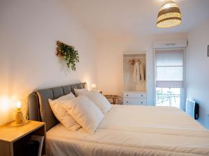 a bedroom with a bed with white sheets and a lamp at Appartement T2 avec grande terrasse et parking - FR-1-553-291 in Balaruc-les-Bains