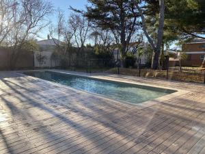 a swimming pool in a yard with a wooden deck at Appartement T2 avec grande terrasse et parking - FR-1-553-291 in Balaruc-les-Bains