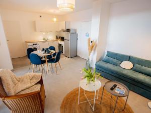 a living room with a blue couch and a table at Bel Appartement T2 Neuf avec Terrasse - FR-1-553-292 in Balaruc-les-Bains
