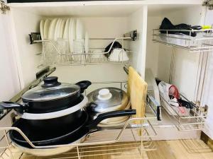 uma panela e frigideiras sentados numa prateleira numa cozinha em 1BR at Trees Residences with Balcony em Quezon City