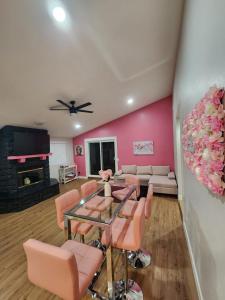 a living room with pink walls and a table and chairs at House of Pink in Joshua Tree