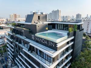 a building with a swimming pool on top of it at Wanda Jin Residences The Ease Sierra Bangkok in Ban Na Song