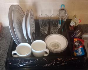 a tray with plates and cups and glasses on a counter at studio apartment bahria Enclave in Islamabad +5 photos