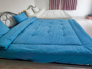 a blue comforter on a bed in a room at Sawasdee Home in Betong