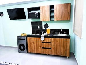 a kitchen with a sink and a microwave at A03 Suite MAX BLACK con COCINA Terraza Perfecta para Familias Compañías Equipos de Trabajo in Cuautitlán Izcalli
