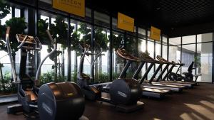 a row of treadmills in a gym with windows at Luxury Sky Pool 8-Pax City Centre Beacon in George Town