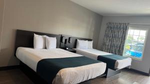a hotel room with two beds and a window at Studio 6 Corona, CA West in Corona +21 photos