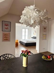 a room with a table with a vase of flowers and a bed at NEW Modern Apartment - 93m2 Central in Pfaffenhofen an der Ilm