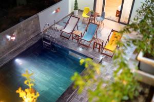 een uitzicht over een zwembad met stoelen en tafels bij Ha Blue Villa-Hoi An in Dien Ban