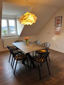 a dining room table with chairs and a chandelier at Komfort-Apartment - 93m2 - Zentral - Nähe Stadtpark in Pfaffenhofen an der Ilm