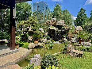 um jardim com um lago e uma cascata em Century Runhua Hotel em Jinan