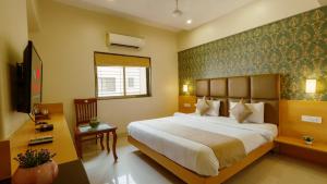 Postel nebo postele na pokoji v ubytování Magnus Square Business Hotel near Pune Airport + 7 fotografií