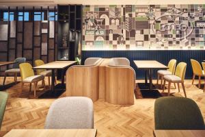 a restaurant with tables and chairs and a wall at Holiday Inn Kyoto Gojo in Kyoto