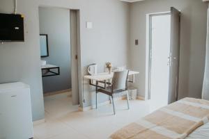 a bedroom with a bed and a table and chairs at Karabelo guesthouse in Groblersdal